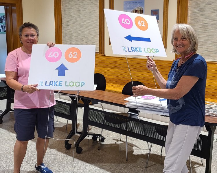 Volunteers assisting with Lake Loop preparation, holding signs for the event