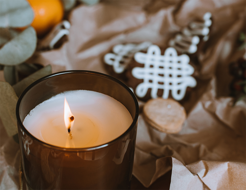 a burning candle with some cookies