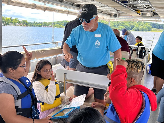 An LHF volunteer assists in a lesson being conducted aboard the Floating Classroom.