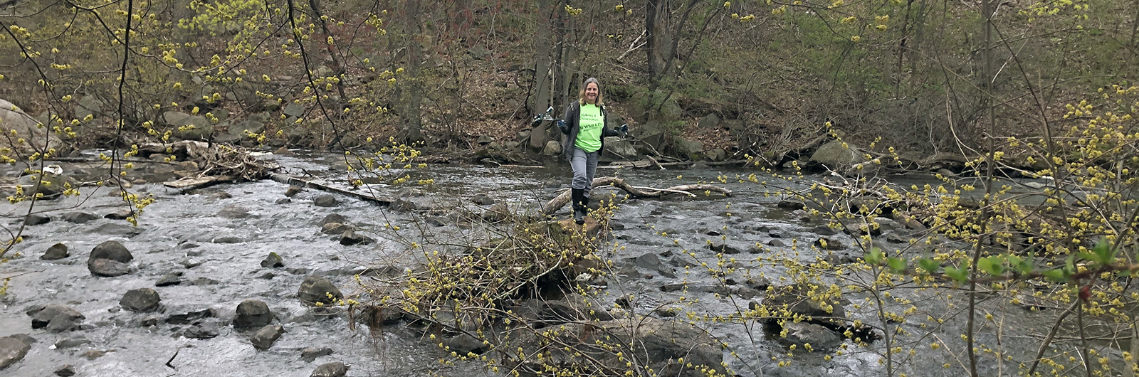 Woman cleaning litter along the Musconetcong River